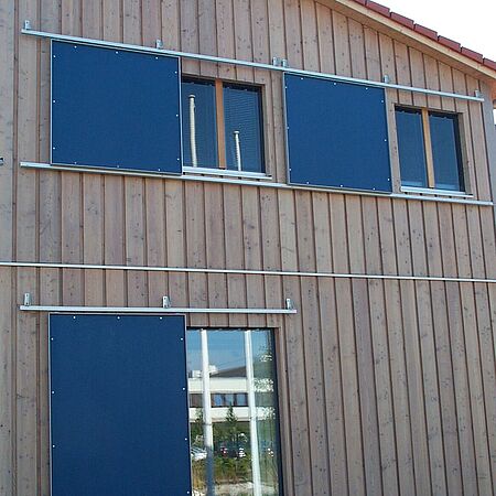 Fassade mit blauen Schieberollos